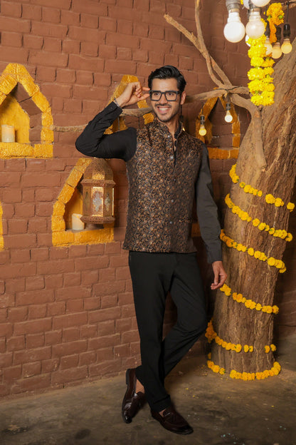 Men's black Nehru or Modi jacket vest with intricate golden botanical print, worn over dress shirt - traditional Indian formal wear
