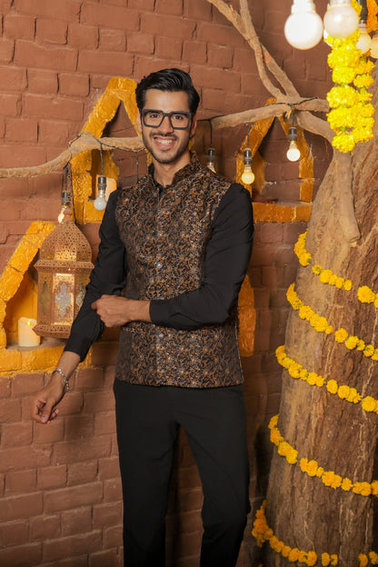 Men's black Nehru or Modi jacket vest with intricate golden botanical print, worn over dress shirt - traditional Indian formal wear