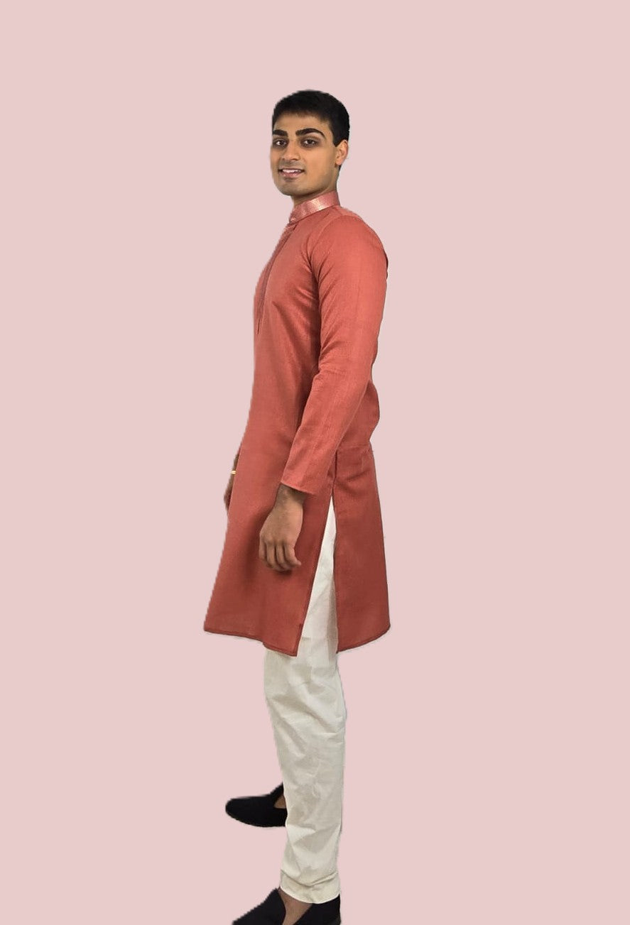Men's rust or deep carrot color kurta with embroidered neckline paired with white churidar, mandarin collar, side pockets, full sleeves - premium Indian formal wear for weddings and special occasions