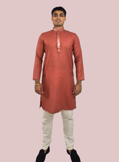 Men's rust or deep carrot color kurta with embroidered neckline paired with white churidar, mandarin collar, side pockets, full sleeves - premium Indian formal wear for weddings and special occasions