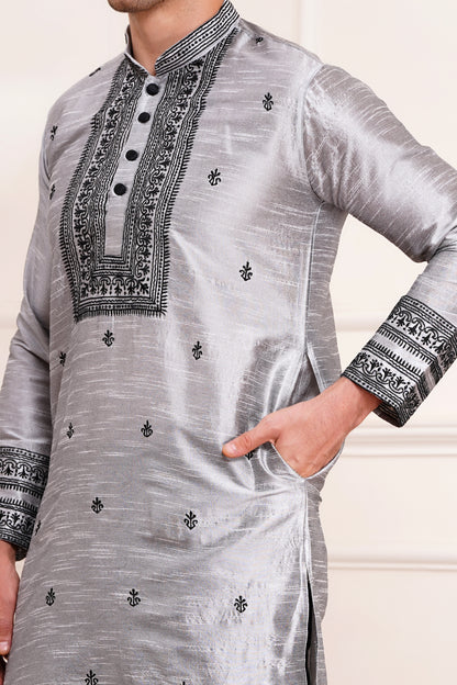 Men's gray silk kurta with black embroidered mandarin collar and cuffs, side pockets, full sleeves with black pants - traditional Indian formal wear for weddings and festivals