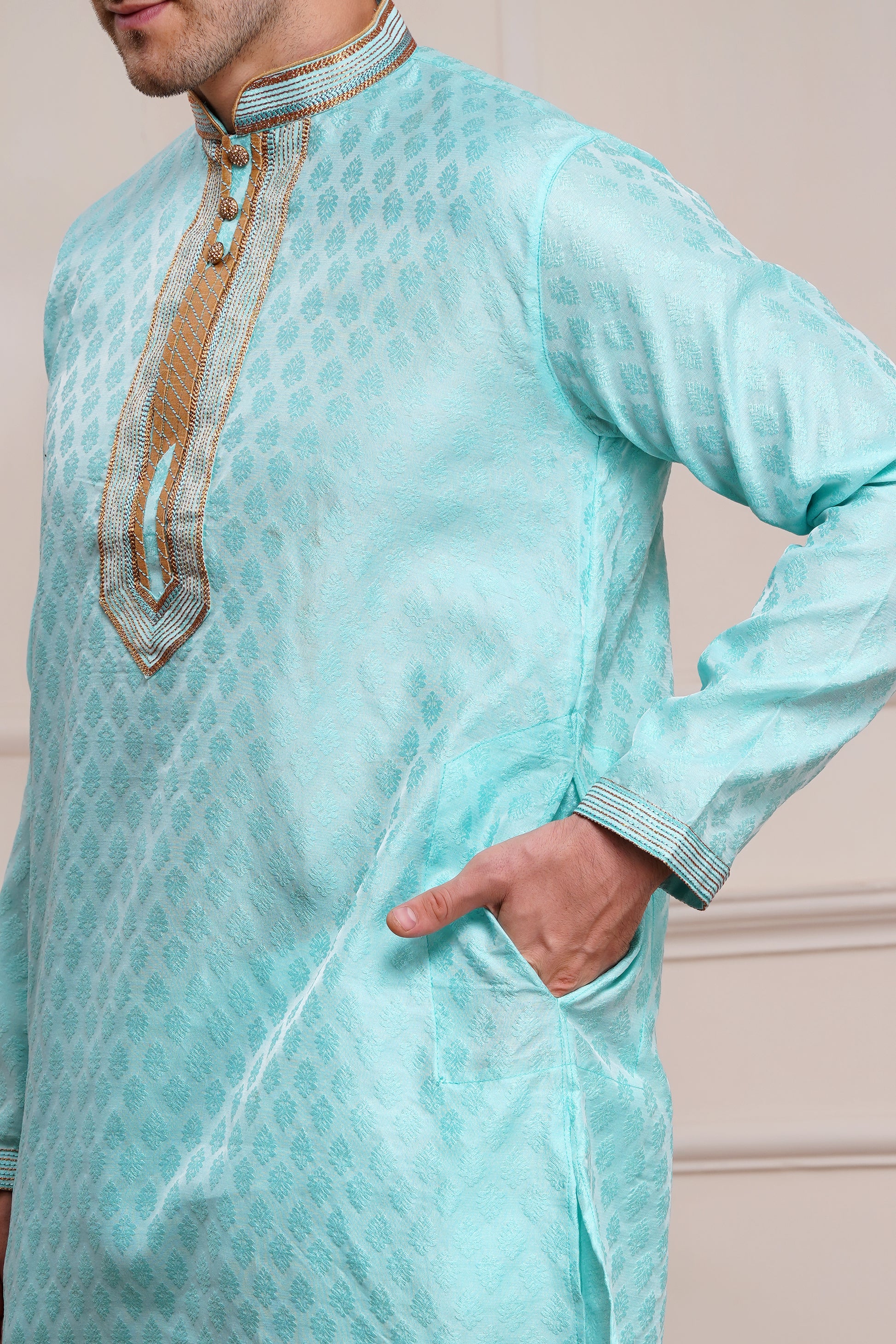 Men's light blue brocade kurta with gold embroidered neckline paired with white churidar, mandarin collar, side pockets, full sleeves - premium Indian formal wear for weddings and special occasions