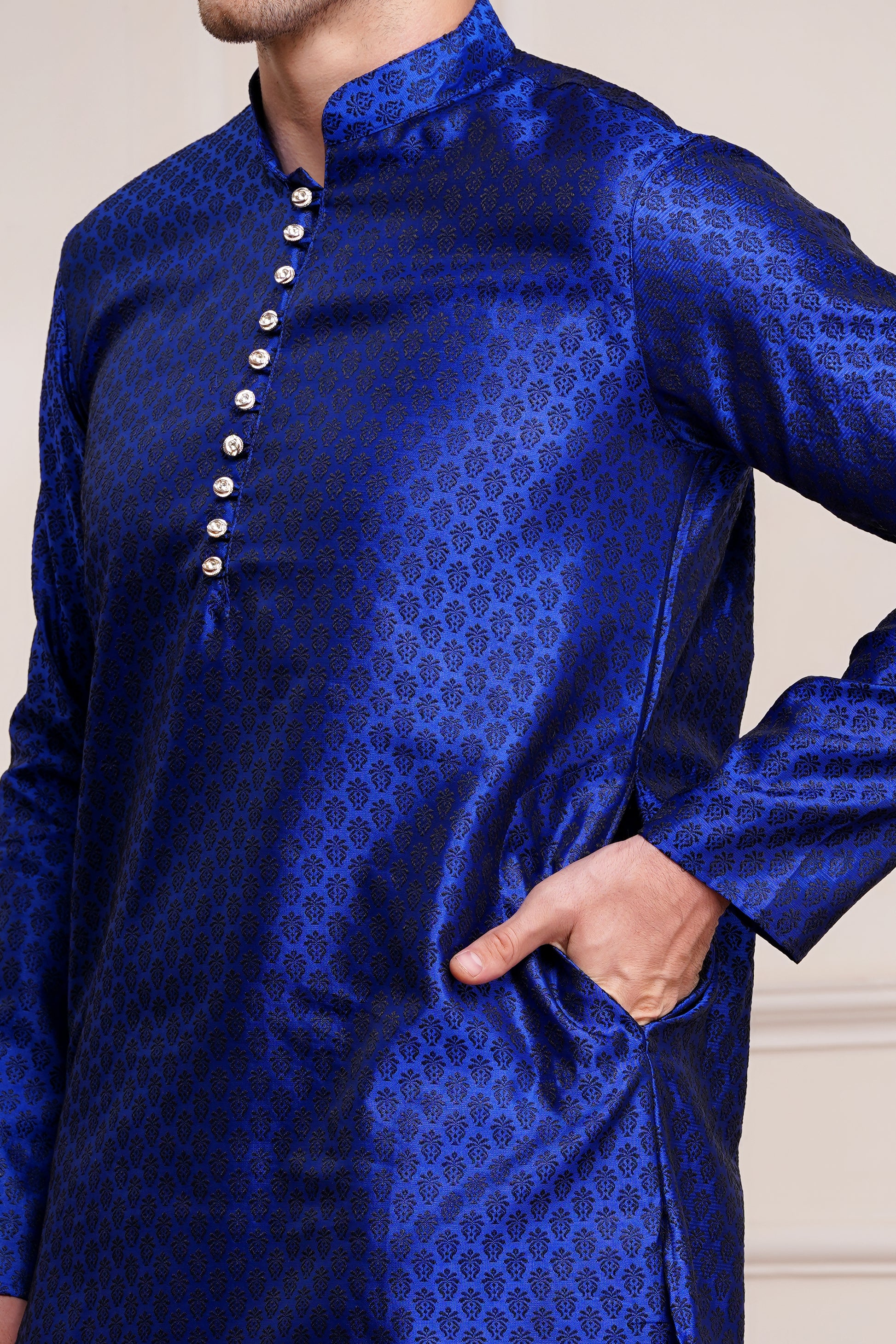 Men's bright blue silk kurta with gold brocade diamond pattern and white churidar pants, decorative buttons with loop closure, mandarin collar, full sleeves, side pockets - traditional Indian festive wear