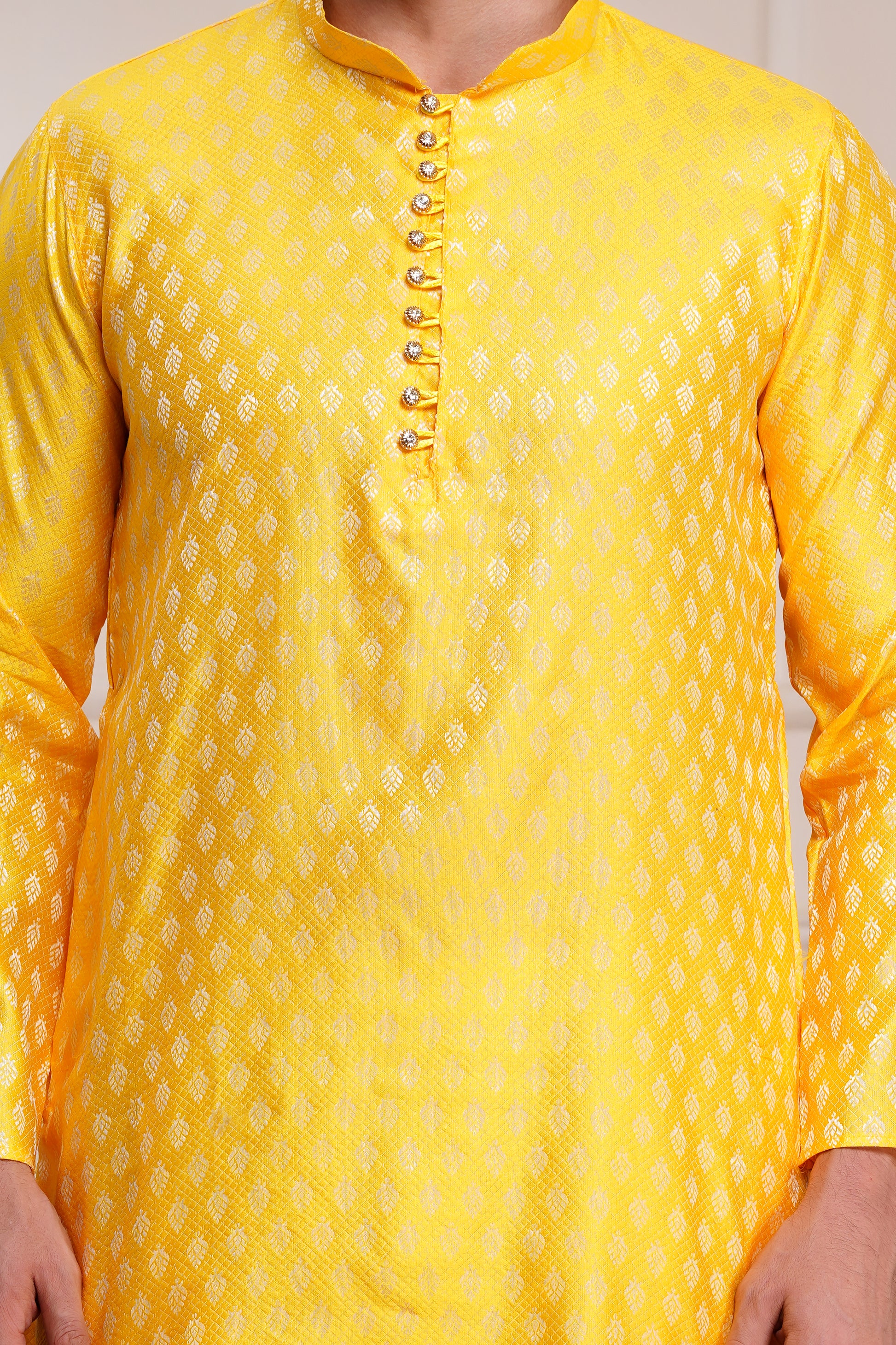 Men's bright yellow silk kurta with gold brocade diamond pattern and white churidar pants, decorative buttons with loop closure, mandarin collar, full sleeves, side pockets - traditional Indian festive wear
