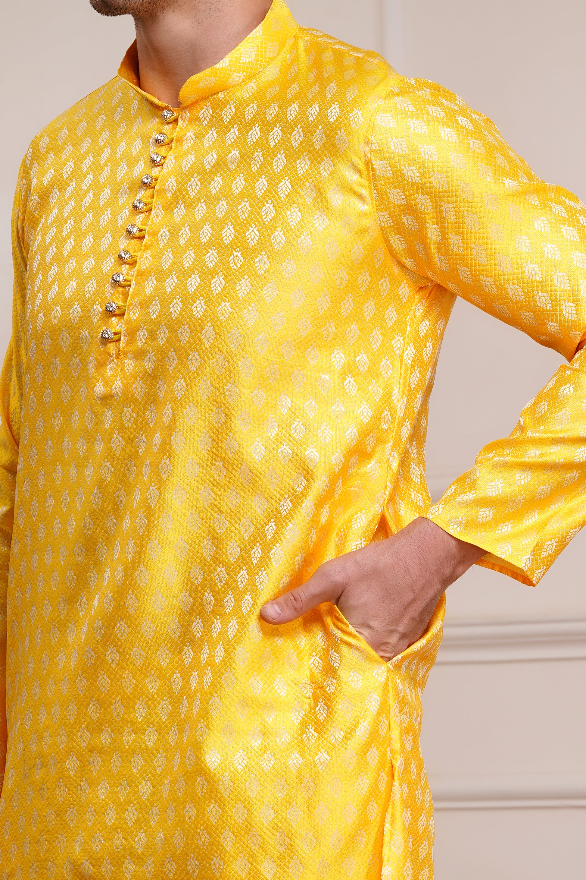 Men's bright yellow silk kurta with gold brocade diamond pattern and white churidar pants, decorative buttons with loop closure, mandarin collar, full sleeves, side pockets - traditional Indian festive wear