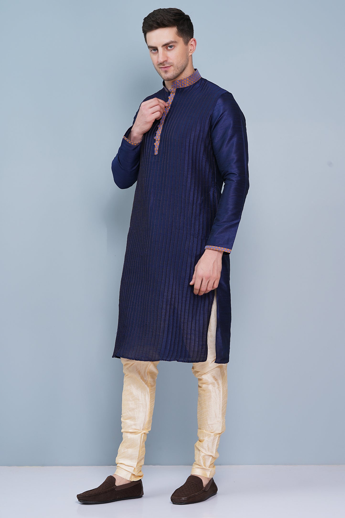 Men Navy Blue traditional Kurta with orange accent  on collar, placket and cuffs, full length, boondi button with loops closure, one fourth placket, full sleeves, mandarin collar, side pockets on Kurta with Off-white or cream color chudidar pajama. Perfect traditional wear for family special occasions, wedding, house warming, casual wear