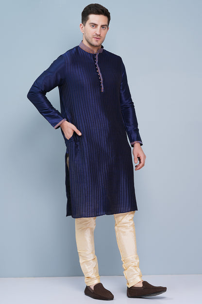 Men Navy Blue traditional Kurta with orange accent  on collar, placket and cuffs, full length, boondi button with loops closure, one fourth placket, full sleeves, mandarin collar, side pockets on Kurta with Off-white or cream color chudidar pajama. Perfect traditional wear for family special occasions, wedding, house warming, casual wear